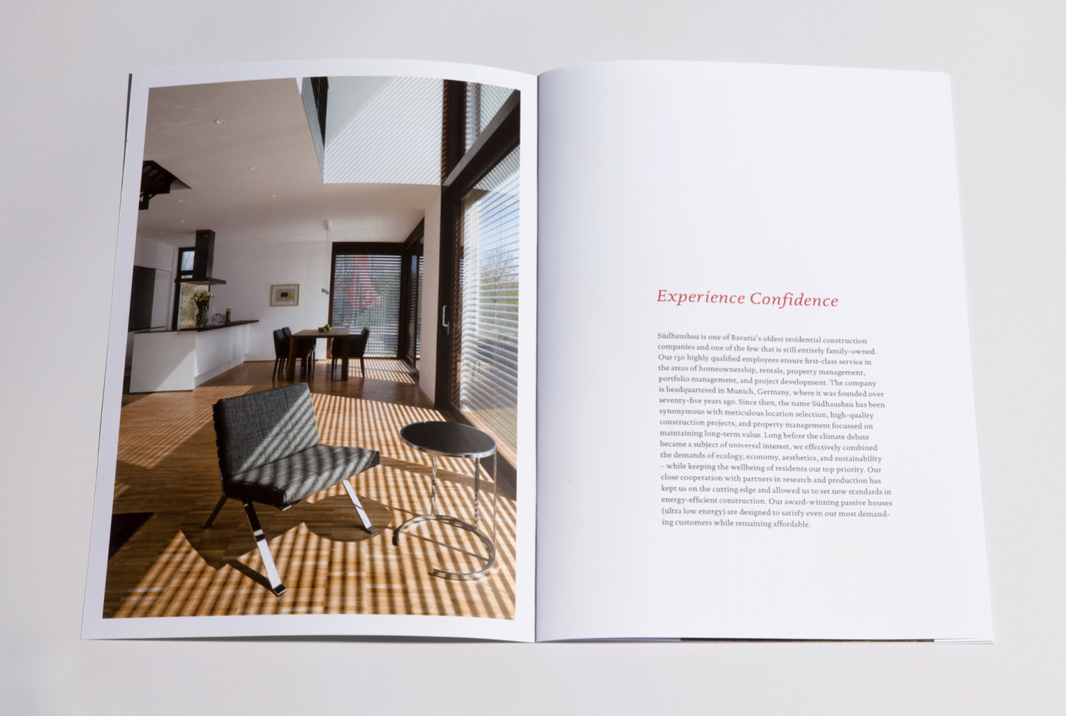 Doppelseite mit ganzseitiger Fotografie eines Koch-Ess-Wohnbereichs und Textseite