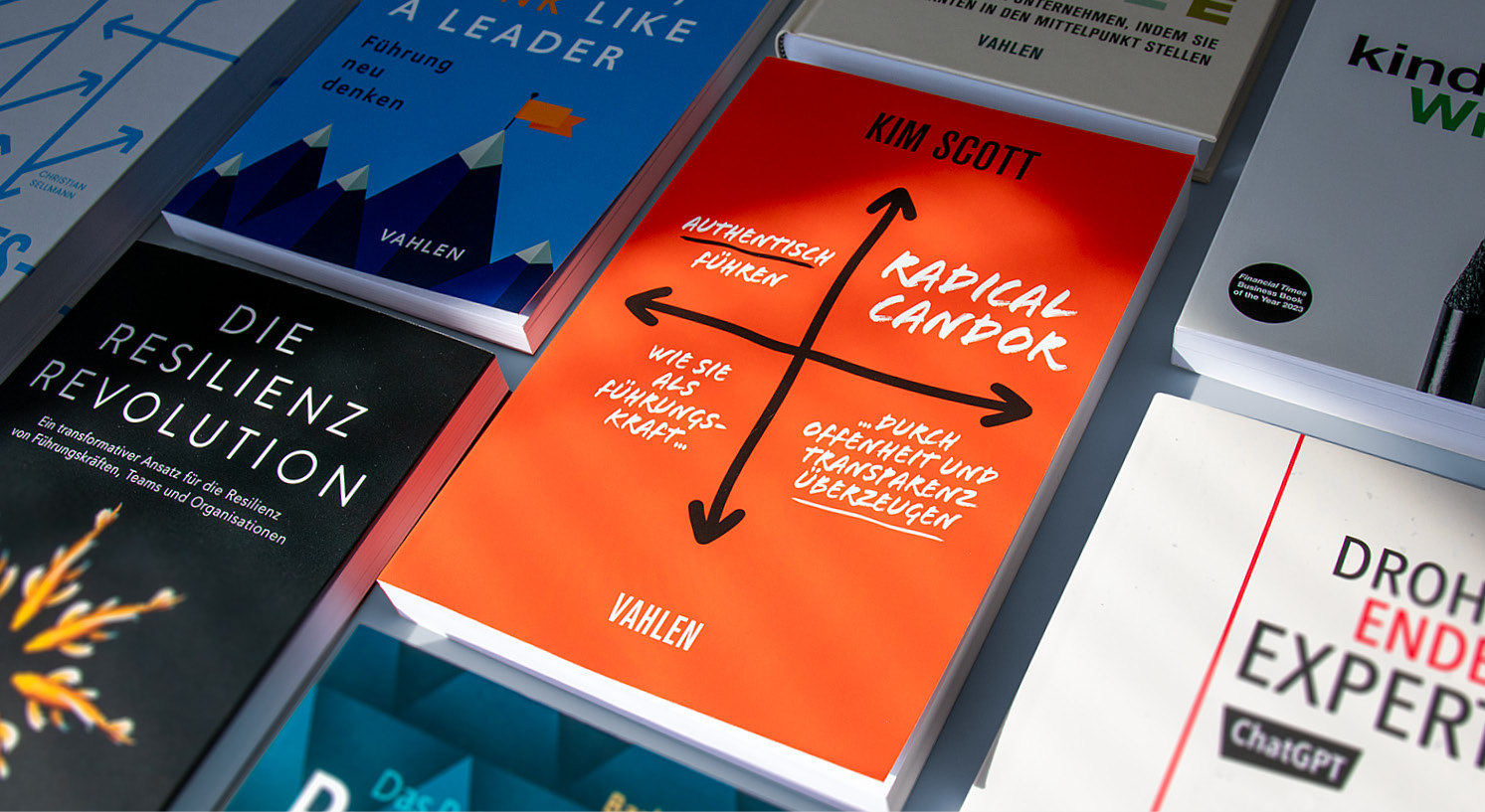 Verschiedene Bücher liegen nebeneinander, unter anderem „Radical Candor – Authentisch führen“ von Kim Scott.