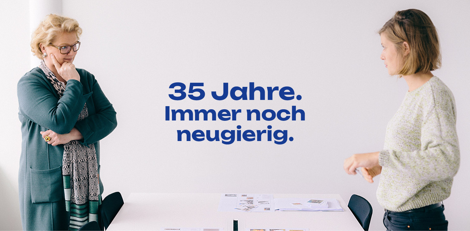 Caroline Sieveking im Gespräch mit einer Mitarbeiterin. Text: 35 Jahre. Immer noch neugierig.